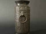 a silver vase with a ring on it on a table