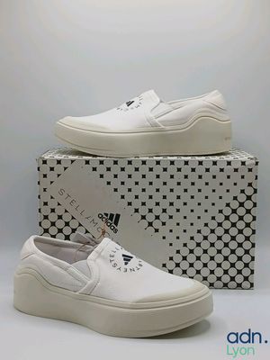 a pair of white shoes sitting on top of a box