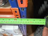 a person holding a measuring tape in front of a shelf