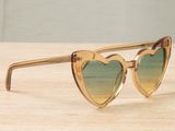 sunglasses with heart shaped frames on a wooden surface