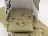 an open book with a picture of a necklace and bracelet on it