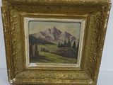 une image d'un tableau représentant une scène de montagne dans un cadre doré