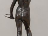 statue of a woman holding a hoop on a wooden table
