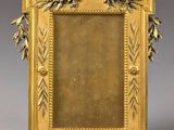an antique gold picture frame with leaves and flowers on a gray background