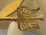 a gold plate with a bird on it and an egg in the middle