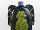 a blue and green vase with a picture of a woman on it
