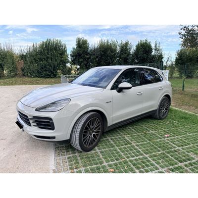 Une Porsche Cayenne blanche est garée sur un parking