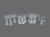 six verres à vin transparents et un verre à vin vide posés sur une surface grise