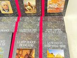 six books on a white table with a red ribbon on them
