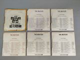 four beatles records are sitting on a table in front of a gray background