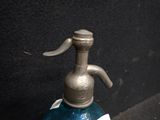 a blue glass bottle with a metal faucet on top of it