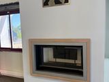 a fireplace in the middle of a room with a painting on the wall