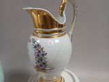 a white and gold vase with blue flowers on it