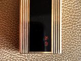 a picture of a gold cigarette case on a brown leather surface