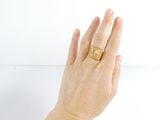 a woman ' s hand with a gold ring on it
