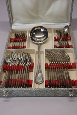 un service d'argenterie avec des manches rouges et des cuillères, présenté dans un coffret