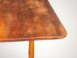 an old wooden table with a wooden top on a gray background