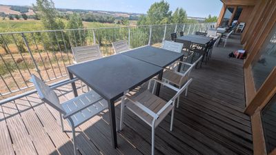 une table et des chaises sur un balcon donnant sur un champ