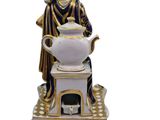 a figurine of a woman holding a tea pot