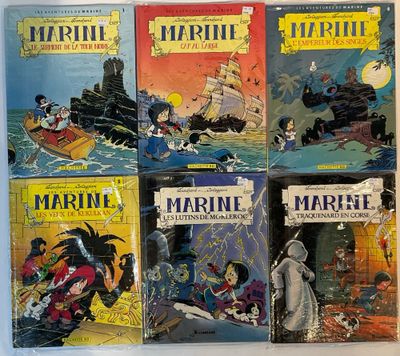 four books of comics are lined up on a white surface