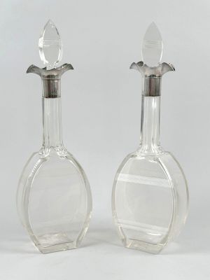 pair of clear glass decanters with a silver top