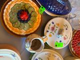 de nombreuses assiettes et bols posés sur une table, avec un vase bleu