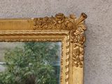 a mirror on the wall with a plant in the reflection
