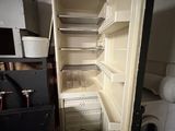 an open refrigerator in a small room with a lot of shelves