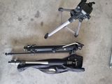 a tripod and a camera on the floor next to a laptop