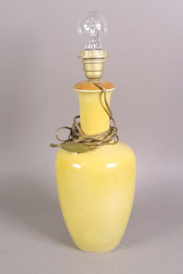 a yellow vase with a light bulb on top of it