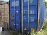 a blue shipping container sitting in the middle of a field