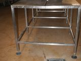 a metal table with a drain in the middle of it