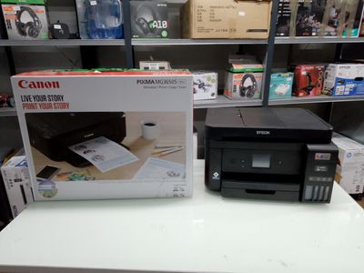 a canon printer sitting on a table next to a box