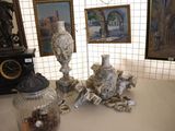 a table with two vases, a clock, and pictures on the wall