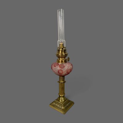une lampe à l'ancienne surmontée d'un abat-jour en verre