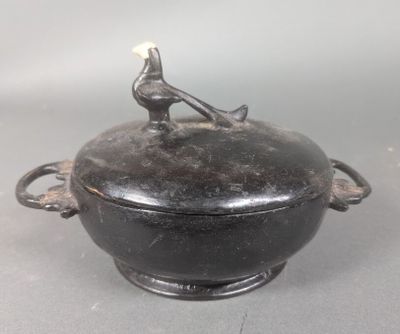 un pot noir surmonté d'un oiseau