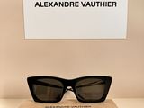 une paire de lunettes de soleil noires posée sur une boîte en carton