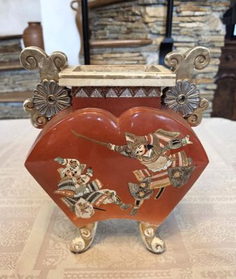une image représentant une boîte rouge en forme de cœur posée sur une table