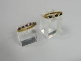 pair of black and white diamond rings on clear acrylic stand