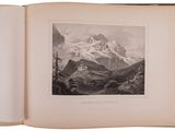 an open book with a picture of a mountain in the background