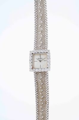 an image of a woman ' s wrist watch with a chain around it