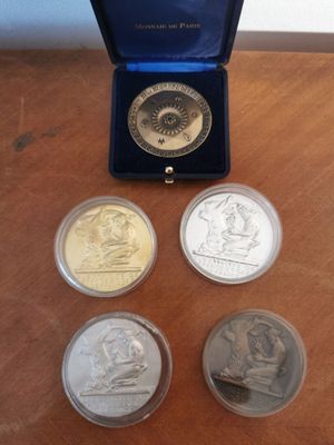 four different coins in a blue box on a wooden table