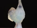 a close up of a glass figurine of a rooster on a table