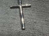 une croix posée par terre à côté d'une paire de ciseaux