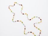 un long collier de perles multicolores sur fond blanc