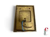 an old brass plate with a blue cord attached to it