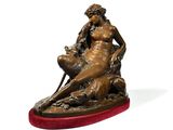 bronze statue of a woman sitting on a rock with a dog