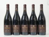 six bouteilles de vin sont alignées sur une table