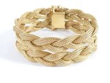 gros plan d'un bracelet en or sur fond blanc