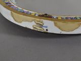 a white plate with a gold rim and a mirror